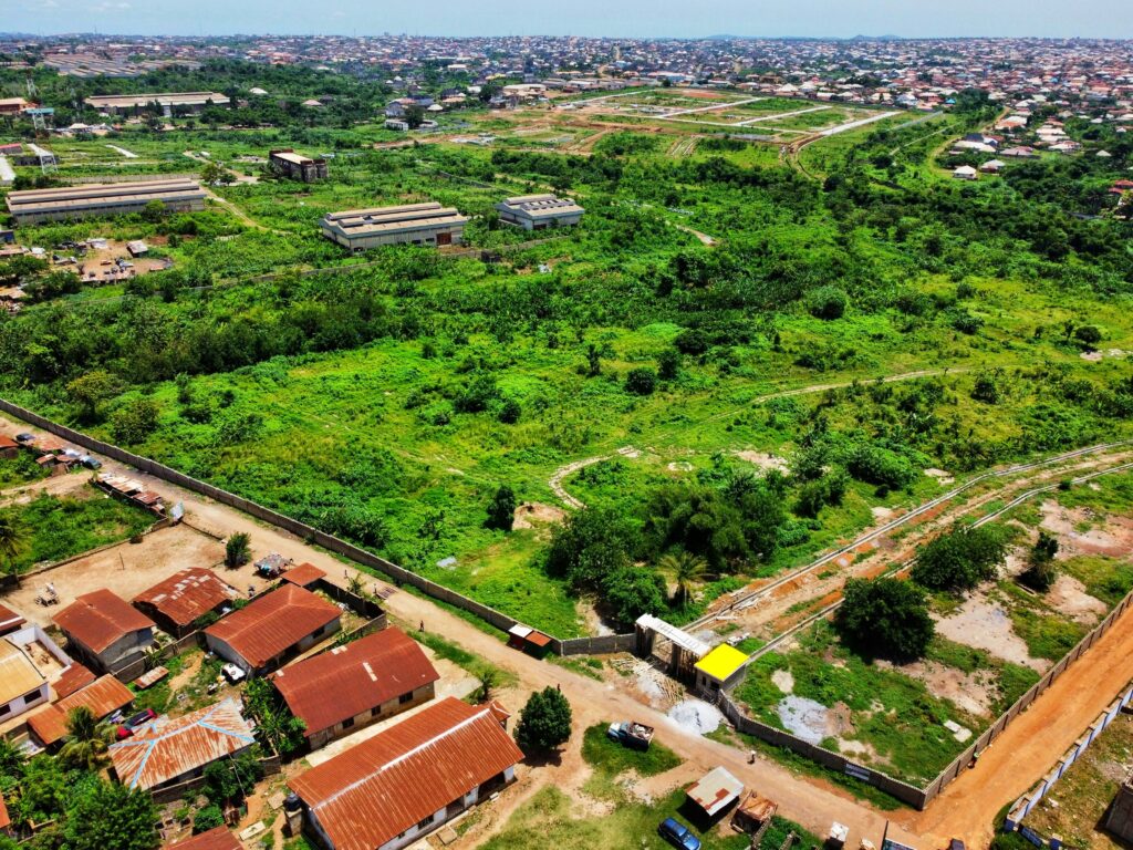 Aerial view of expanding residential land development in Nigeria showing new housing layouts and green urban space.