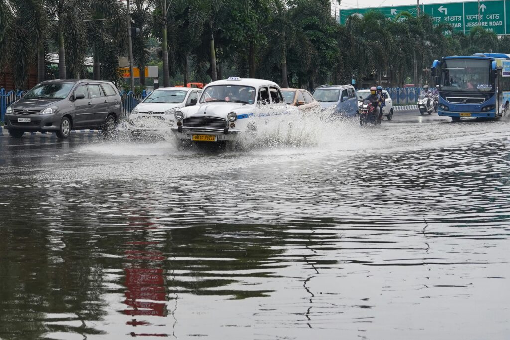 Cars driving through a heavily flooded urban road showing climate resilience challenges in Nigerian real estate