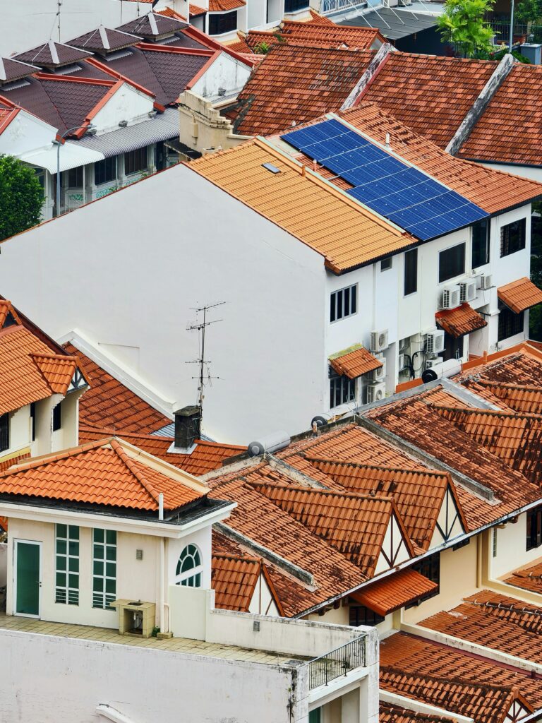 Aerial view of residential rooftops with one house fitted with solar panels showing the growth of solar powered homes in Nigerian real estate