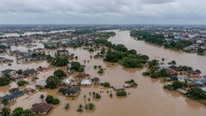 Flooded residential neighbourhood in Nigeria with submerged houses and rising brown water