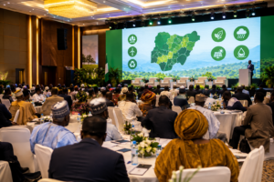Nigerian officials and delegates seated at a climate summit in Abuja with a regional climate marketplace backdrop