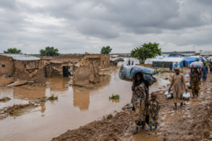 Flooded street with submerged homes and a canoe in a Rivers State community, Nigeria